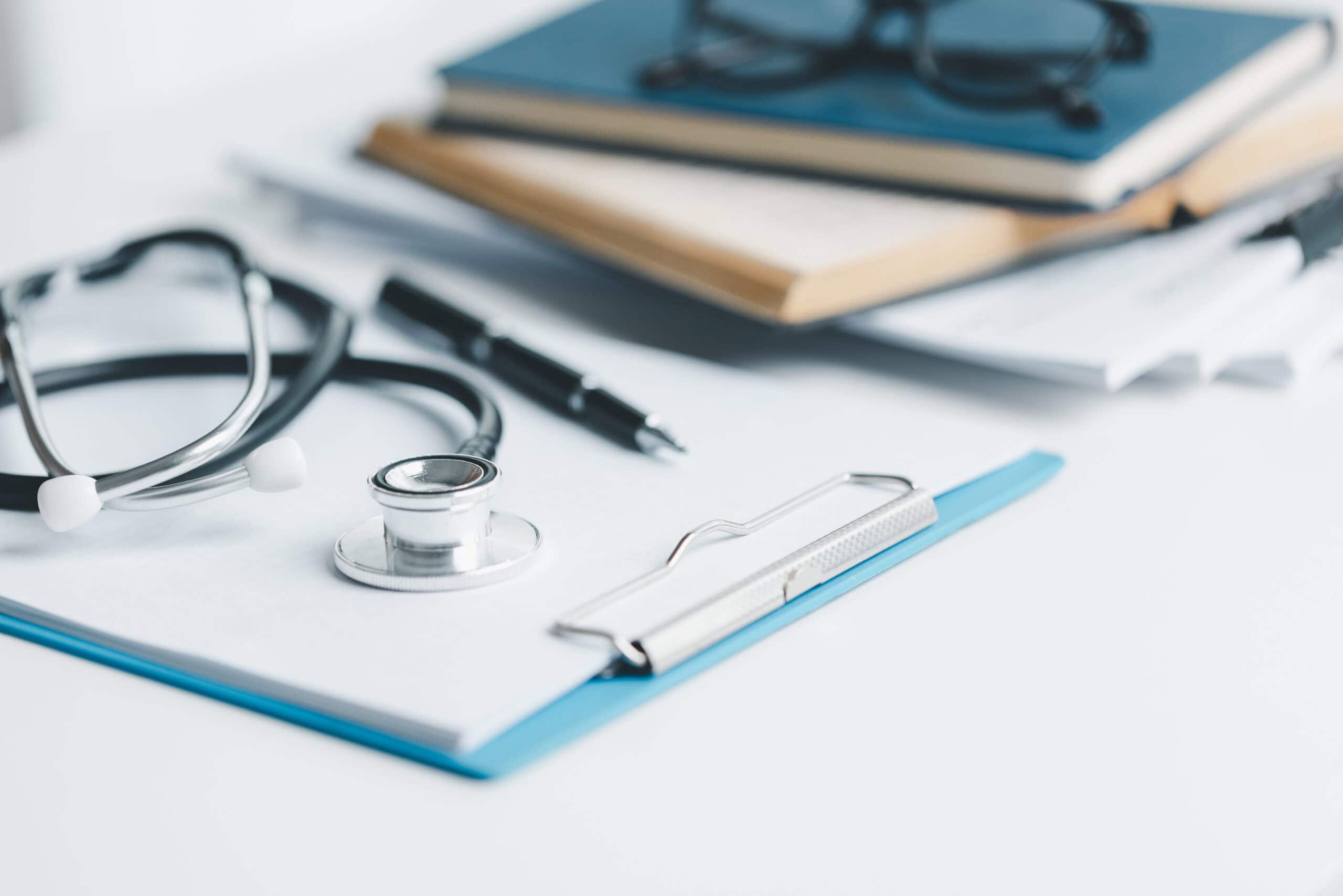 primary care stethoscope and clipboard on desk 