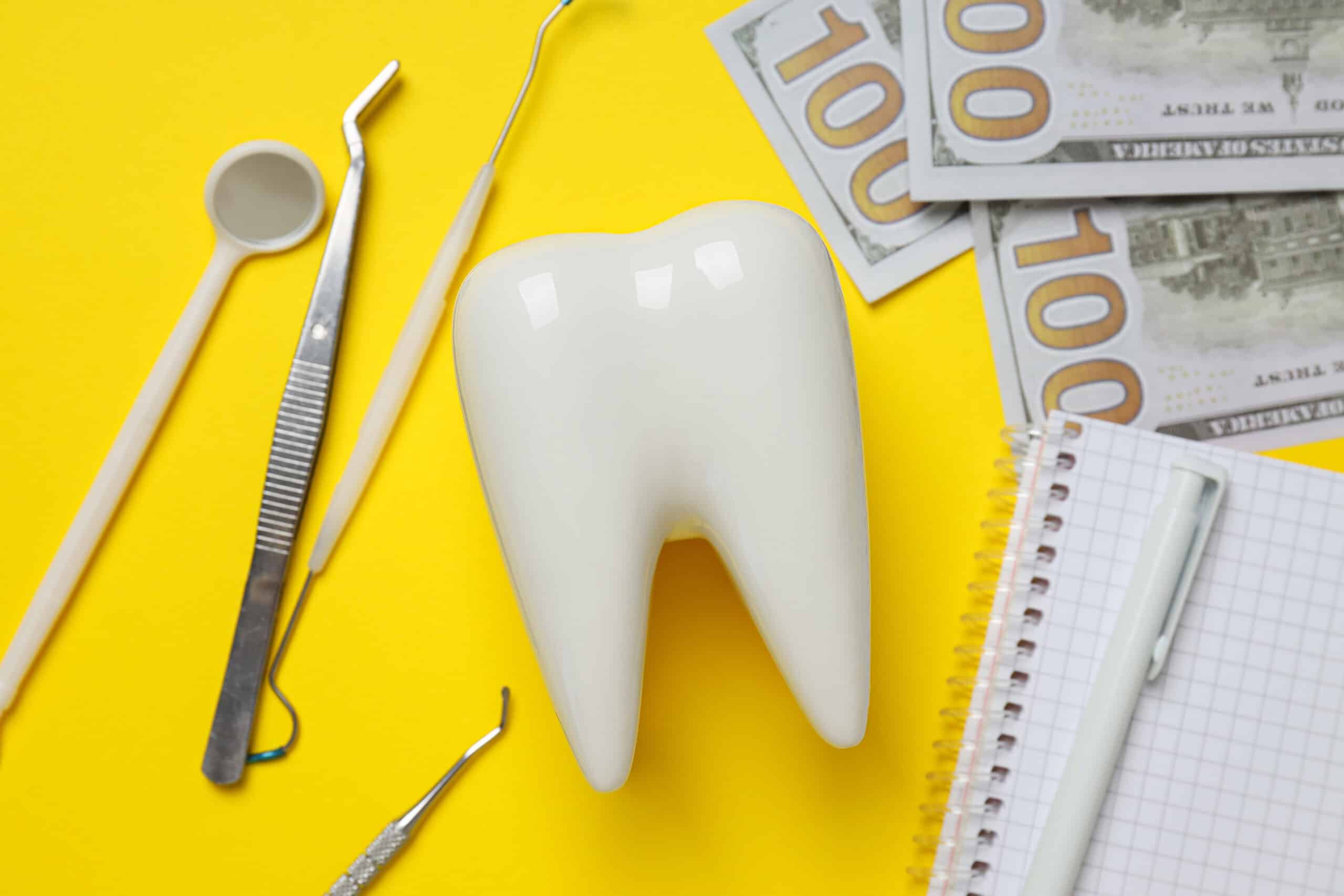 Dental tools money decorative tooth and notepad on yellow back - Website Design | McWilliams Media |Broken Arrow, OK